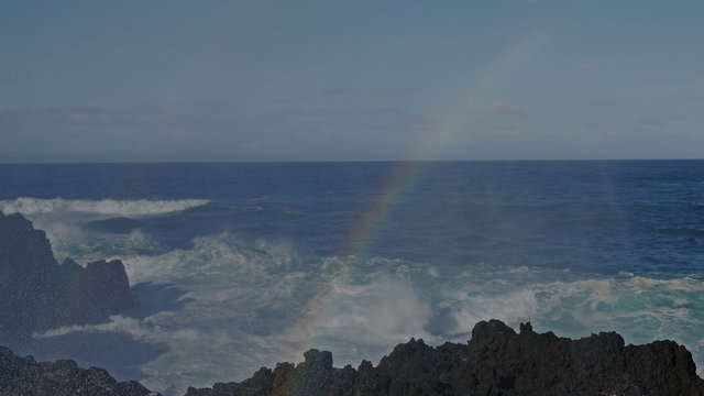 Wave splash with rainbow on the rocks, Azores, Portugal
