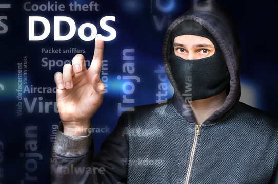 Masked anonymous hacker is pointing on DDoS Attack