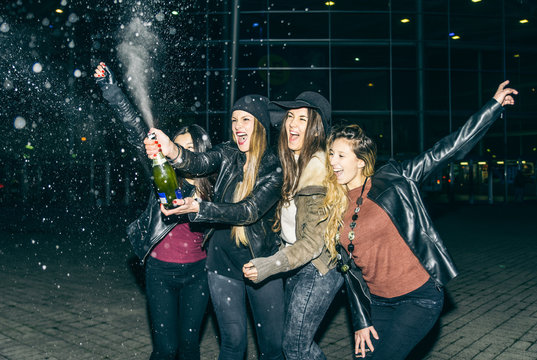 Girls partying and uncorking champagne bottle