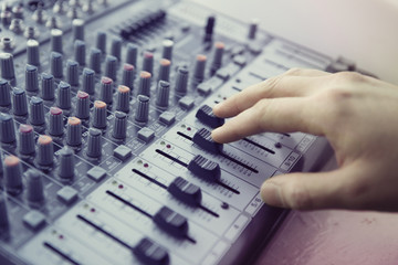 Expert adjusting audio mixing console