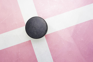 old hockey puck is on the ice with denmark flag