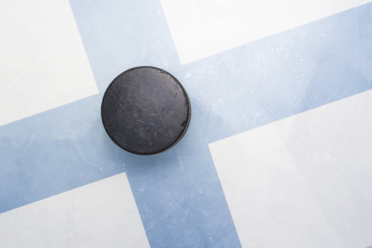 old hockey puck is on the ice with finland flag
