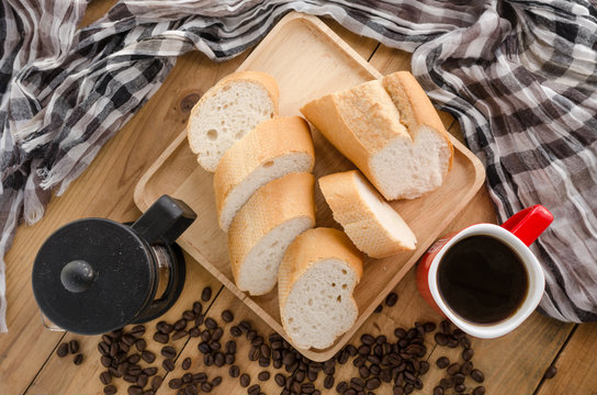 Americano in red cup with coffee beans on wooden background