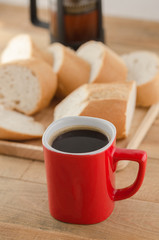 Americano in red cup with sliced bread on wooden background