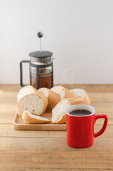Americano in red cup with sliced bread on wooden background