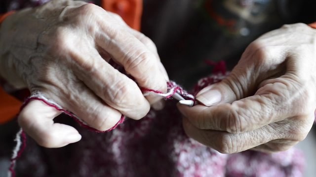 Detail of the hands of a senior person sewing