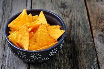 Corn Tortilla Chips or Nachos with tomato sauce on wooden table