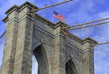 Fototapeta premium Most Brooklyński z amerykańską flagą i błękitne niebo, Nowy Jork, USA