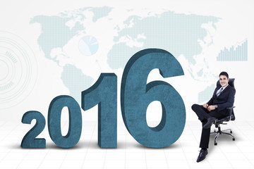 Confident businessman with numbers 2016 and map