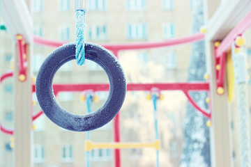 Freezing gymnastic rings. Snowy playground. Frost.