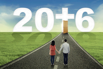 Couple looking at numbers 2016 on the road