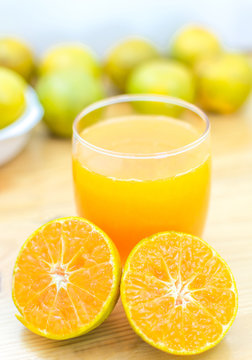 Glass of fresh tangerine,  orange juice with sliced orange on wo