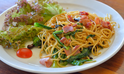 spaghetti with bacon on white plate
