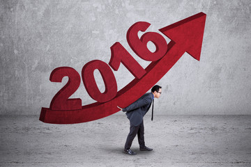 Man carrying upward arrow with numbers 2016