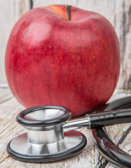 Medical stethoscope with an apple. Healthy lifestyle concept image.