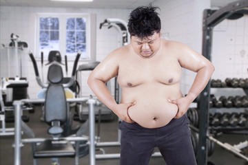 Fototapeta na wymiar Overweight Man Grabbing his Fat