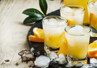 Orange soft drink with juice, vodka and ice, selective focus