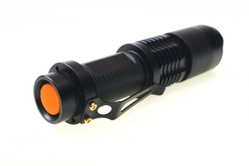 Black flashlight on white background (selective focus)