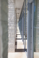 modern architecture corridor separating glass and stone facades