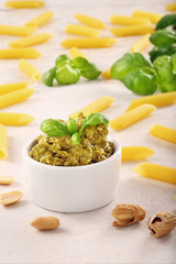 Green basil pesto in white bowl