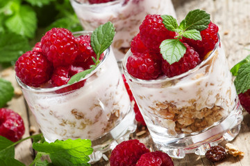Fresh ripe raspberries with homemade yogurt, mint and muesli on