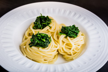 Pasta with spinach on white plate
