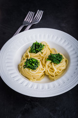 Pasta with spinach on white plate