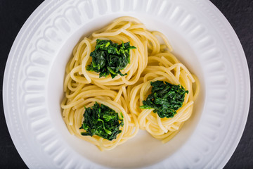 Pasta with spinach on white plate