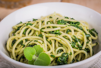 Pasta with spinach on white bowl