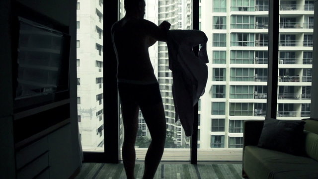 Man putting on shirt and admire vie from window, super slow motion 120fps
