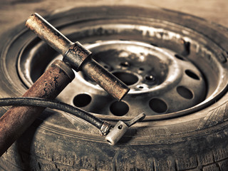 old hand-pump and car wheel close-up