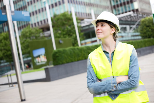 Young Woman Wearing A Construction Hard Hat And Reflective Yellow Jacket