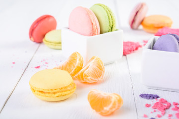 French Macaroons With Tangerine Slices On Wood Table