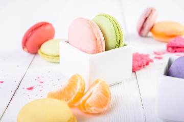 French Macaroons With Tangerine Slices On Wood Table