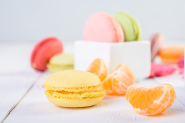 French Macaroons With Tangerine Slices On Wood Table