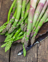 Fresh green asparagus on old wooden table