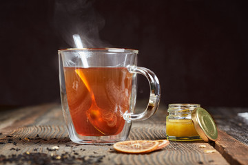 Steaming tea and honey on a wooden table