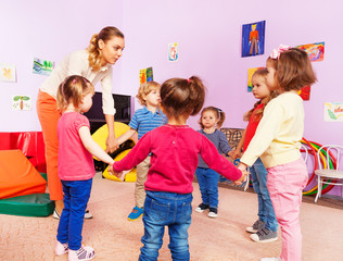 Teacher and group of kids in kindergarten 