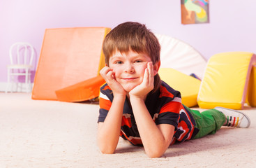 Boy lay on floor and hold head with hands
