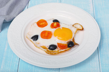 fried eggs with cherry tomatoes and olives