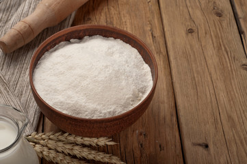 Flour on wooden table closeup