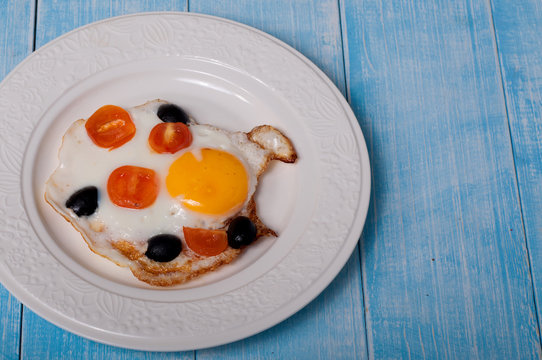 fried eggs with cherry tomatoes and olives
