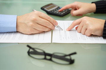 businesswoman is reviewing document with tax consultant and maki