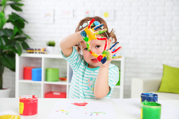 Fototapeta premium hands in colored paint happy child girl