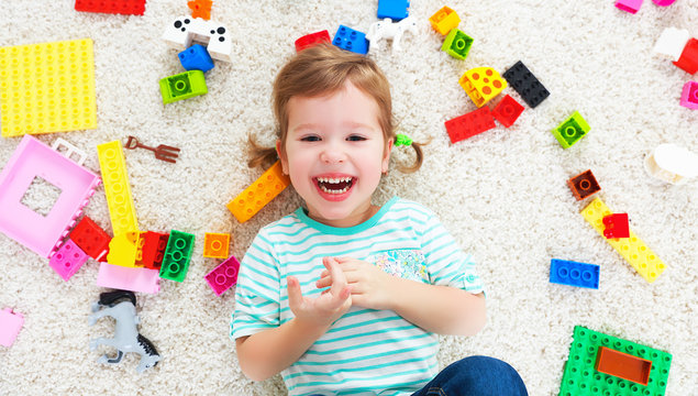 happy child laughing and playing with toys constructor