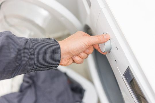 Man is choosing Eco Program on the Washing Machine,concept of el