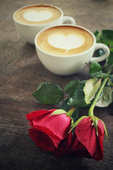 Two cups of latte art coffee with red rose