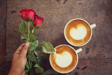Fototapeta na wymiar Two cups of latte art coffee with red rose