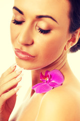 Fototapeta na wymiar Woman with purple orchid petal on shoulder