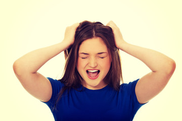 Frustrated young woman screaming.